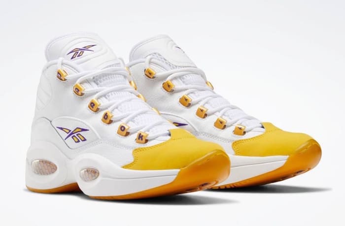 View of white and yellow Reebok shoe.